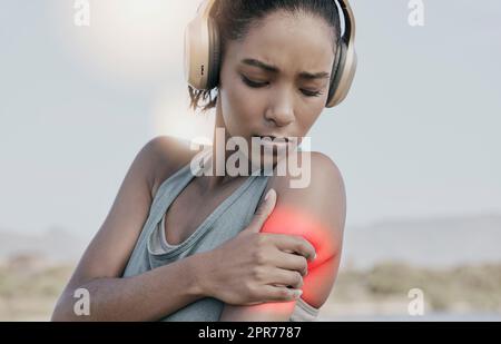 Atleta femminile con dolore alle spalle dopo un intenso allenamento. Giovane donna sportiva con un infortunio o un braccio ferito evidenziato in rosso. Una donna atletica che soffre di infiammazione o muscolo rigido Foto Stock