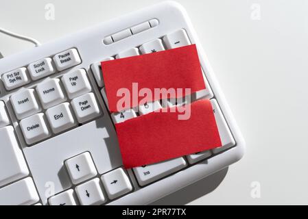 Nota adesiva strappata con messaggi importanti sulla tastiera sulla scrivania. Promemoria a parte strappato con due diverse informazioni Crutial. Annunci recenti presentati. Foto Stock