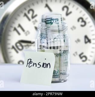 Un po' prima di allora: Una nota che legge la pensione contro un vaso pieno di soldi. Foto Stock