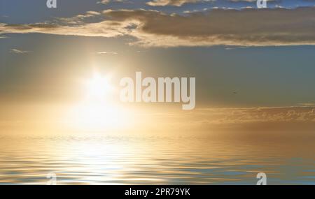 Alba all'orizzonte, raggi di luce che brillano sulle calme acque oceaniche con il copyspace. Armonia pacifica e aria fresca, dettagli di increspature e motivi sulla superficie dell'acqua. Splendido tramonto sulle morbide onde blu Foto Stock