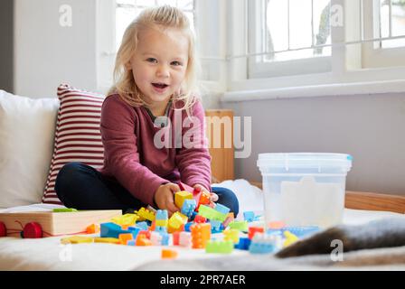 Essere creativi con il lego. Una bambina che gioca a casa. Foto Stock