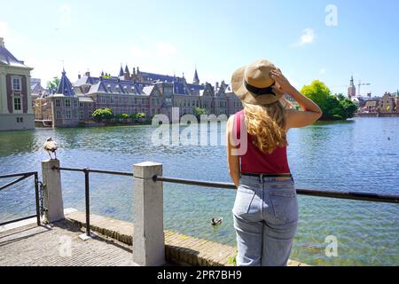 Turismo in Olanda. Giovane ragazza che guarda al complesso di edifici di Binnenhof a l'Aia, Paesi Bassi. Foto Stock