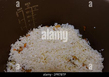 Cuocere passo dopo passo il riso con carne e verdure in un pentolino multiplo a pressione. Aggiungere il riso, il pilaff Foto Stock