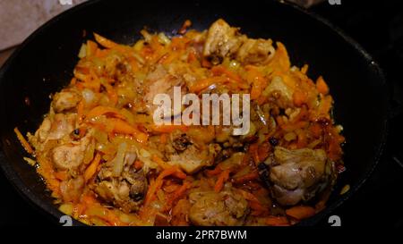 Piatto di pollo piccante coreano fatto in casa, friggere il peperoncino con la carota in una padella con olio di girasole. Foto Stock