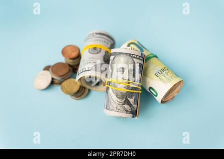 Banconote in dollari internazionali, le monete si trovano accanto a bande di gomma contorte di denaro. Luogo per un'iscrizione. Foto Stock