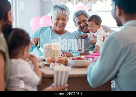 L'amore è condivisione. Foto di una famiglia che festeggia un compleanno insieme a casa. Foto Stock