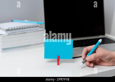 Donna d'affari che tiene la penna sulla scrivania con il piano di lavoro, libri e note con dati importanti. Donna con matita in una mano sul tavolo con computer, notebook e Appunti con nuove idee. Foto Stock