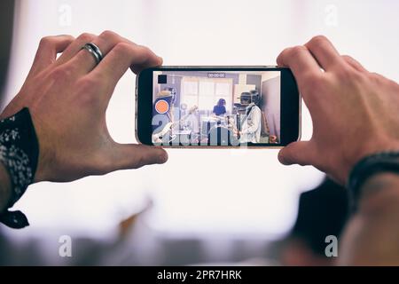 È troppo bello non registrare. Una persona irriconoscibile che registra una band che pratica a casa. Foto Stock