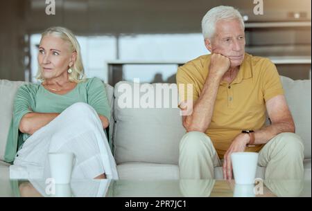 Coppia anziana infelice seduta su un divano insieme dopo discutere. Uomo e donna caucasica anziana in cerca di stress e pronto per il divorzio Foto Stock