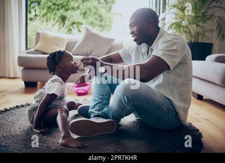 Mangia tutto e riceverai un dessert. Un padre che mangia sua figlia a casa. Foto Stock