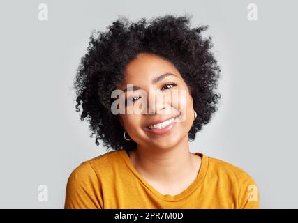 Ho giurato di mettere prima la mia felicità. Studio girato di una bella giovane donna sorridente mentre in piedi su uno sfondo grigio. Foto Stock