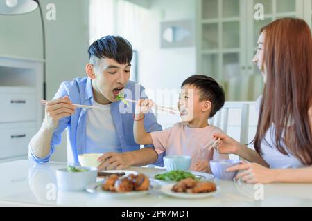 Una felice famiglia asiatica che cena a casa Foto Stock