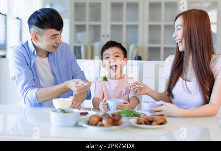 Una felice famiglia asiatica che cena a casa Foto Stock