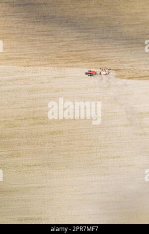 Vista aerea. Trattore con seminatrice semina semi per colture nella stagione primaverile. Inizio della stagione primaverile agricola. Paesaggio rurale. Sfondo rurale naturale Foto Stock