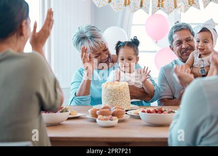 Questa potrebbe essere la sua canzone preferita. Foto di una famiglia che festeggia un compleanno insieme a casa. Foto Stock