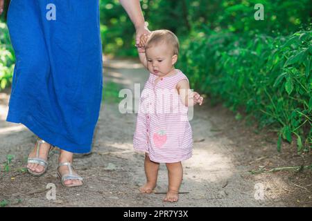 La mamma insegna a sua figlia a camminare nella foresta Foto Stock