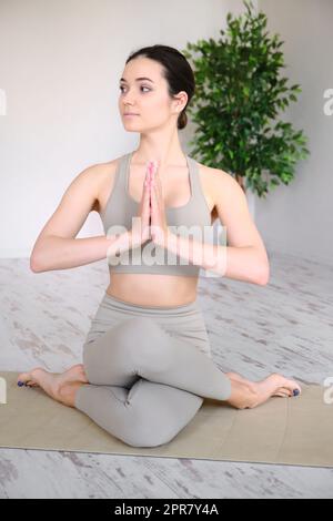 La giovane donna pratica lo yoga in studio. La ragazza medita all'aperto. Foto Stock