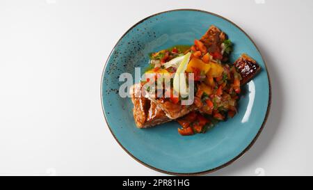 Filetto di salmone glassato con salsa di mango, erbe e limone Foto Stock