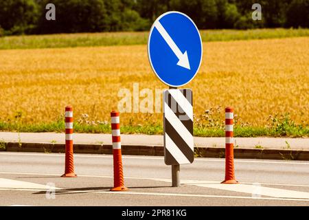 Coni arancioni e segnali stradali per il controllo del traffico Foto Stock