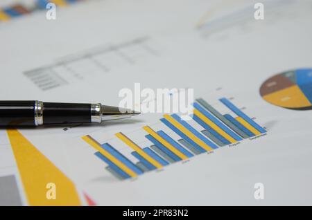 Documenti di business rapporti grafici e grafici e penna su carta statistiche finanziarie crescita investimento conto analisi pianificazione in ufficio. Foto Stock