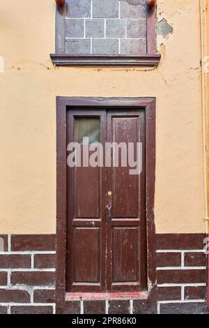 Vecchia casa o chiesa con vernice sbucciante su parete o finestra e porta a serranda in legno. Edificio residenziale d'epoca e vecchio costruito in uno stile architettonico o design tradizionale a Santa Cruz de la Palma Foto Stock