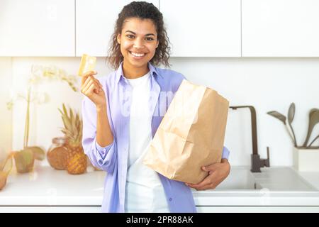 Donna sorridente con un sacchetto ordinato online Foto Stock