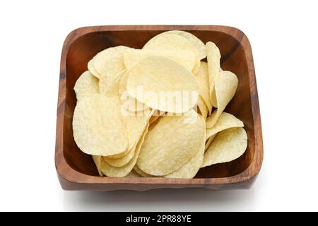 Patatine in ciotola di legno su sfondo bianco, primo piano. Foto Stock