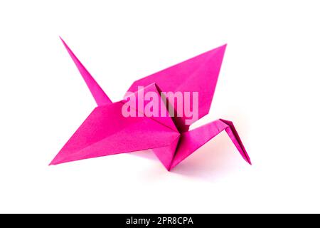 Origami di gru di carta rosa isolato su sfondo bianco Foto Stock