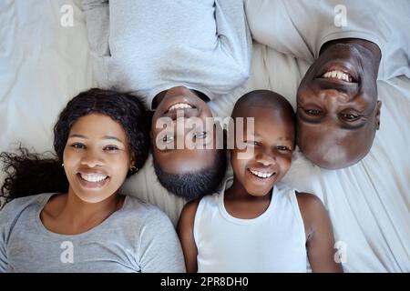 Una famiglia felice è solo un cielo più vecchio. Scatto di una bella famiglia giovane che si unisce a letto insieme. Foto Stock