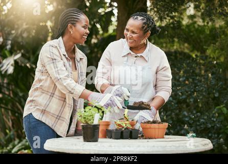 L'amore tra madre e figlia vive per sempre. Sparato di una madre e figlia giardinaggio insieme nel loro cortile. Foto Stock