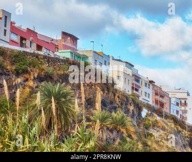 Vista sulla città di case o edifici residenziali su una scogliera di Santa Cruz, la Palma, Spagna. Storico spagnolo, architettura coloniale e palme in un villaggio tropicale di famosa destinazione turistica Foto Stock