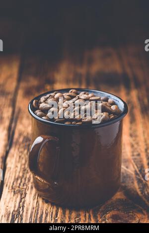 Tazza piena di chicchi di caffè tostati Foto Stock