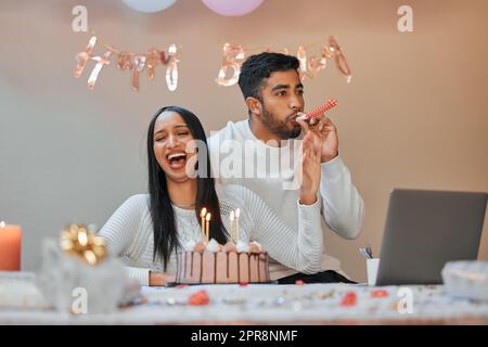 Facciamo iniziare questa festa. Una giovane coppia che festeggia un compleanno a casa. Foto Stock