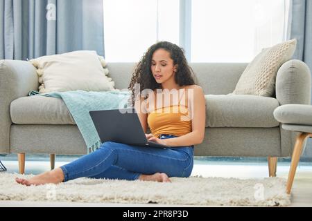 Il grind non si ferma mai. Una giovane donna che usa il suo laptop per fare un po' di lavoro. Foto Stock