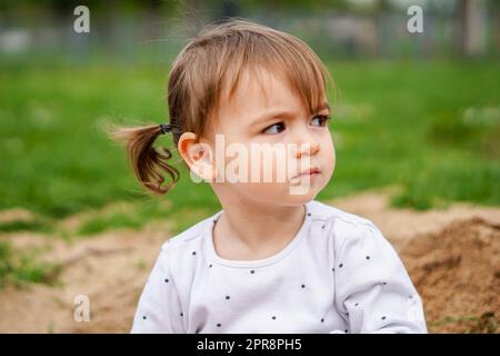 Ritratto di bambina - Pigtail bambina primo piano - Kid in natura focusing face Foto Stock