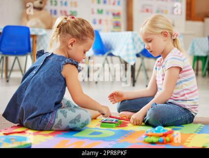 Le attività e le esperienze musicali aiutano i bambini a praticare abilità importanti. I bambini imparano a conoscere gli strumenti musicali in classe. Foto Stock