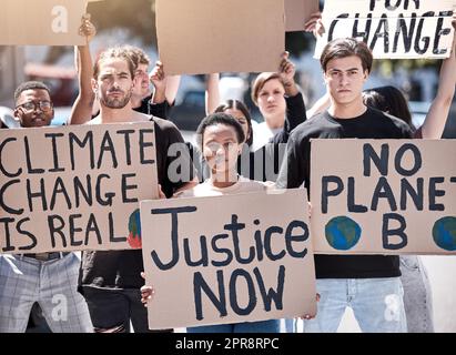 Un gruppo di giovani durante un raduno di proteste con cartelli. Foto Stock