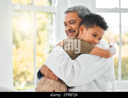 Mi sento già meglio, un ragazzino che dà un abbraccio al medico a casa. Foto Stock