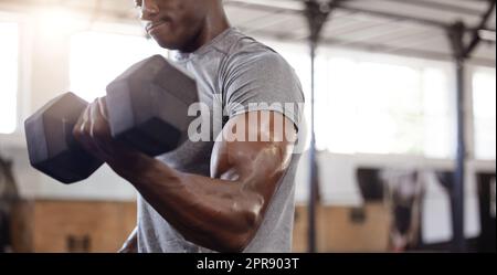 Atleta afroamericano sconosciuto che solleva il manubrio durante l'allenamento con il braccio ricurvo bicipite in palestra. Forte, in forma, allenamento uomo nero attivo con peso in club di salute e sport. Procedura di sollevamento pesi Foto Stock