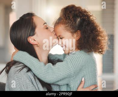 L'informalità della vita familiare è una condizione benedetta: Una madre e una figlia seduti sul divano a casa. Foto Stock