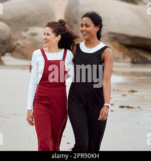 Ho solo bisogno di una spiaggia e di un clima caldo: Due giovani donne attraenti che si alzano insieme sulla spiaggia. Foto Stock