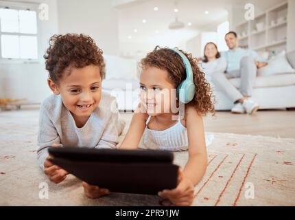 Posso guardare. Un fratello e una sorella che usano un tablet digitale insieme a casa. Foto Stock