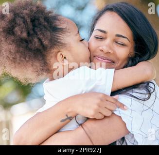Le gioie di essere una madre, una bambina che dà un abbraccio alla madre. Foto Stock