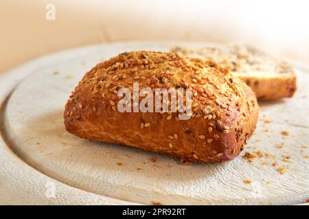 Primo piano del pane appena sfornato in una panetteria con spazio per la copia. Scopri i panini di segale fatti in casa, pronti per essere consumati e gustati come un pasto delizioso. Dettagli macro di un panino con semi freschi visualizzati su un contatore Foto Stock