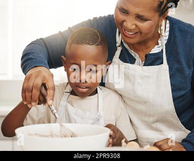 Ragazzo dolce, dolci dolci, una nonna che cuoce con il nipote a casa. Foto Stock