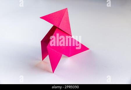 Carta rosa gallina origami isolato su sfondo bianco Foto Stock