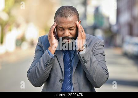 Ho pensato che uscire dall'ufficio sarà d'aiuto. Un uomo d'affari che soffre di un mal di testa mentre si è in città. Foto Stock