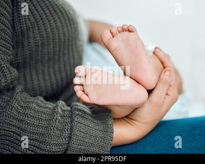 Questa piccola settimana camminerà il loro senso a destra nel vostro cuore. Closeup shot di una donna che tiene le sue bambine piedi piccoli. Foto Stock