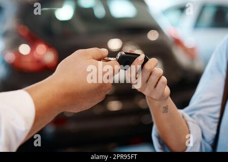 Benvenuti nella vostra nuova vita. Un venditore auto che consegna le chiavi a un cliente. Foto Stock