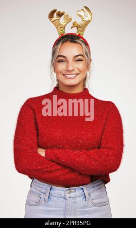 Che non siate mai troppo cresciuti fino a godere il Natale. Studio girato di una giovane donna che indossa una testa di renna su uno sfondo grigio. Foto Stock